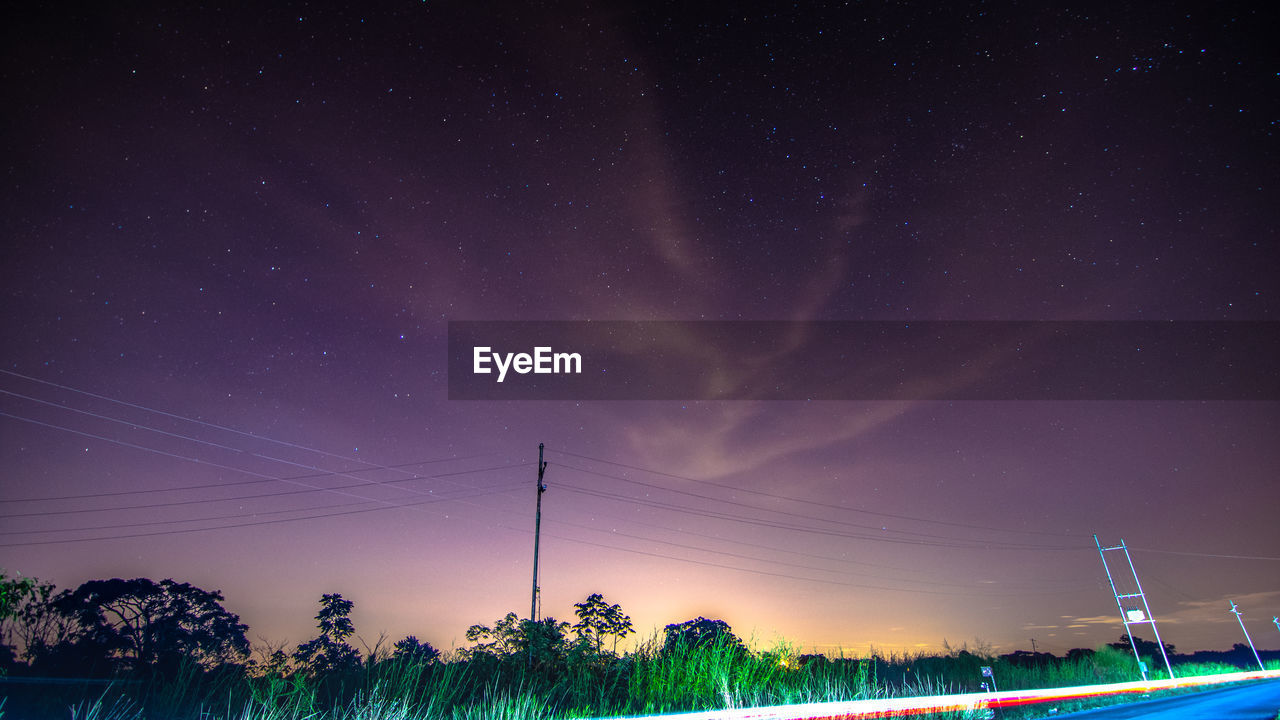 LOW ANGLE VIEW OF ILLUMINATED LIGHTS AGAINST SKY