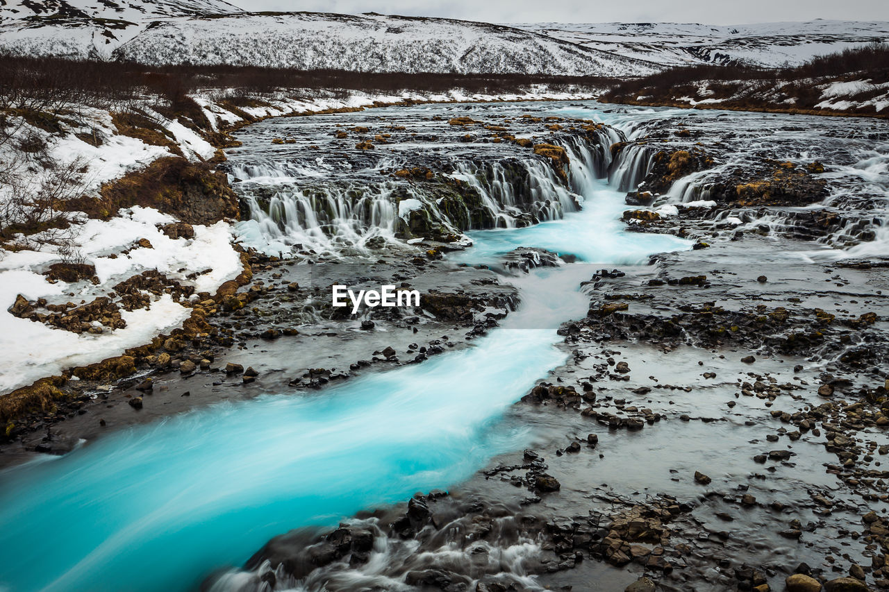 River flowing amidst landscape during winter