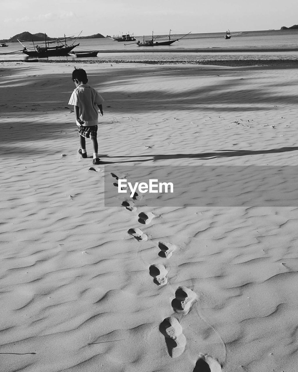 Boy walking on sand at beach