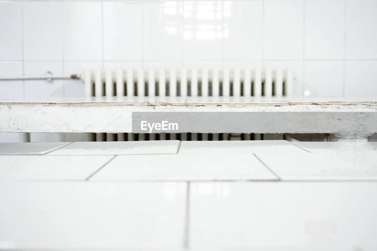 High angle view of radiator on wall by tiled floor in hospital