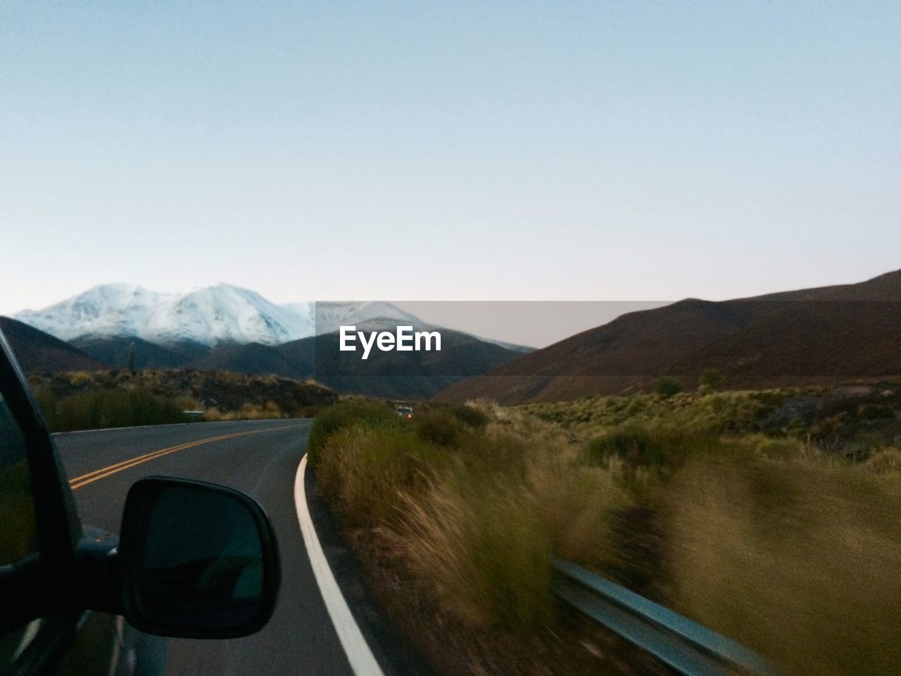 Road by mountains against clear sky