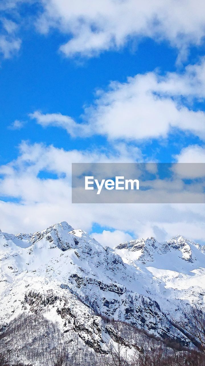 Scenic view of snowcapped mountains against blue sky