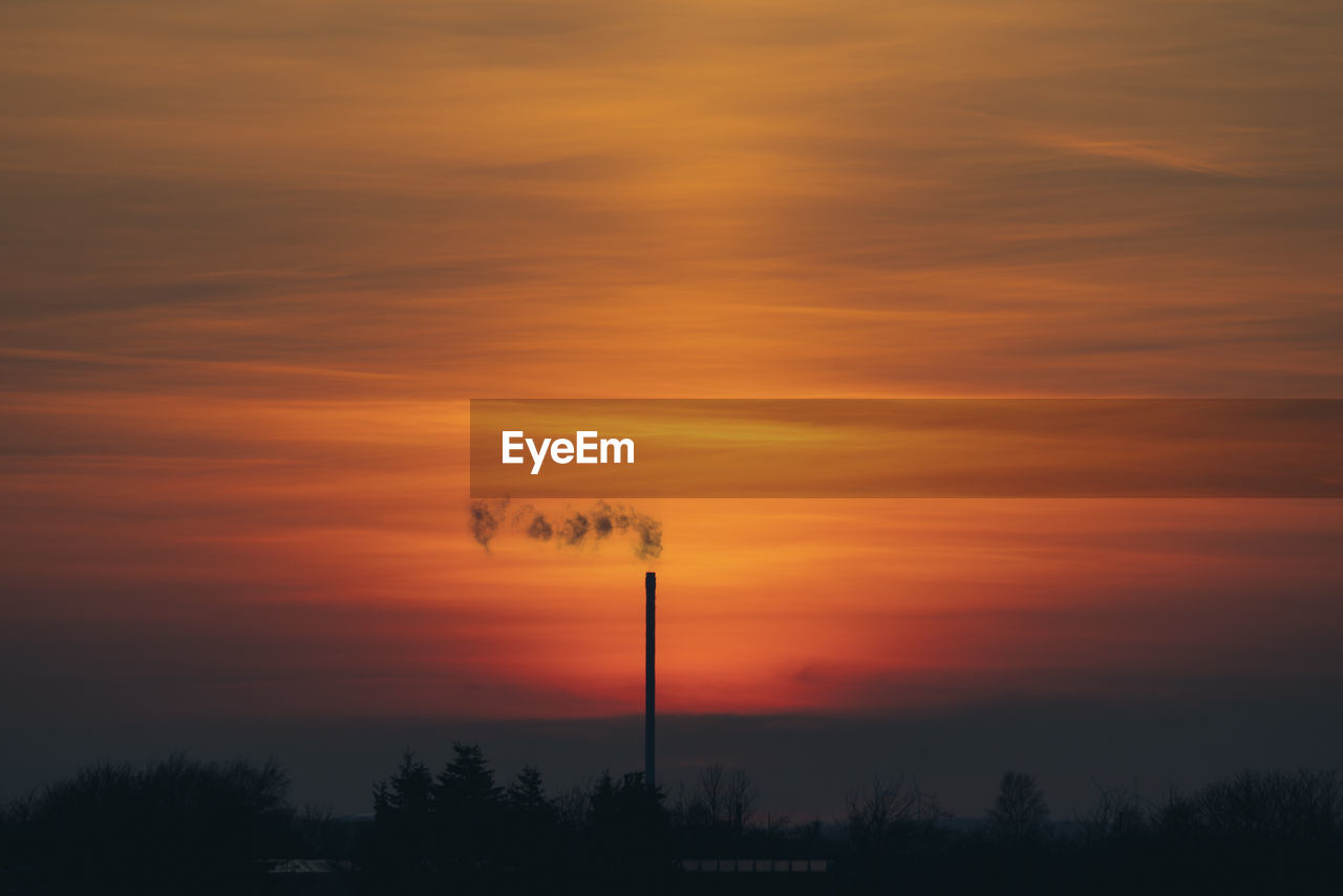 LOW ANGLE VIEW OF SILHOUETTE TREES AGAINST DRAMATIC SKY DURING SUNSET