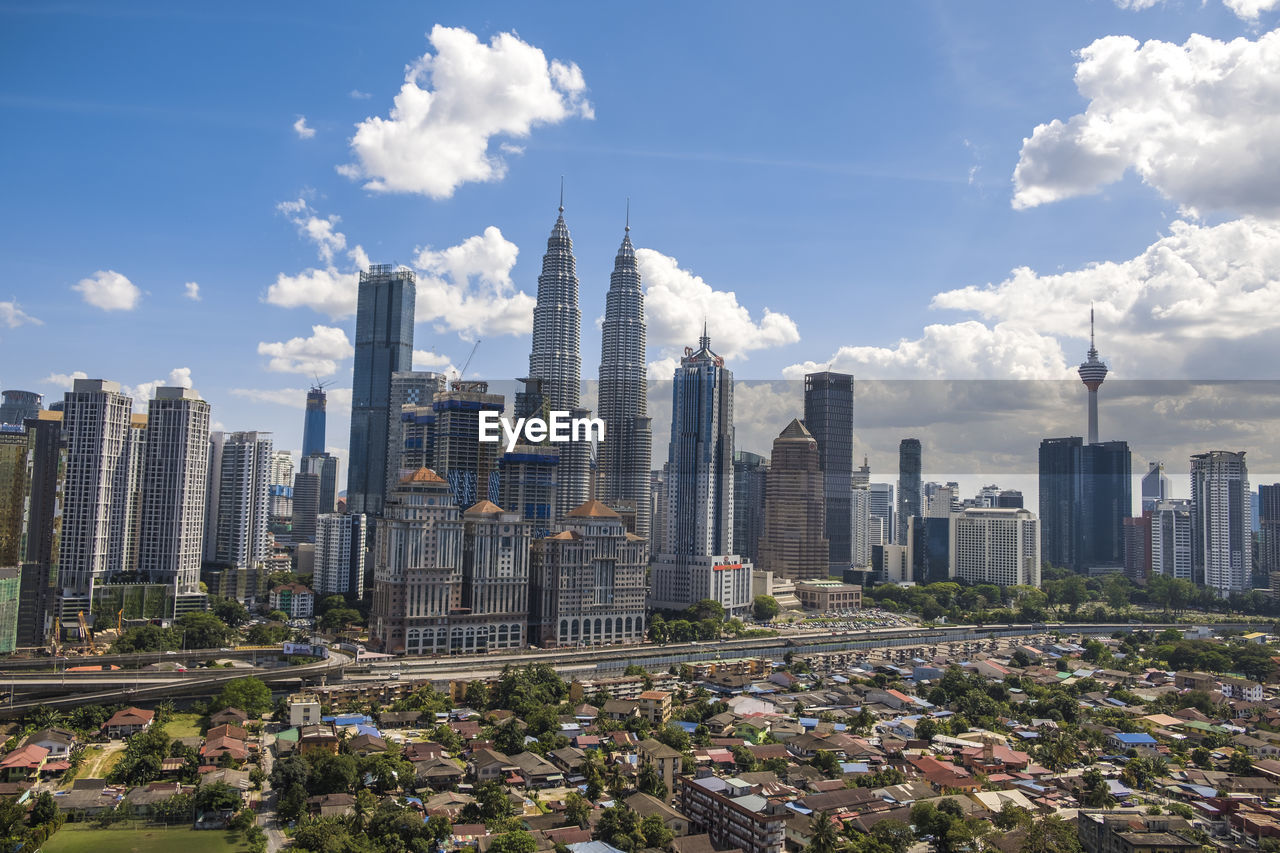 View of cityscape against cloudy sky