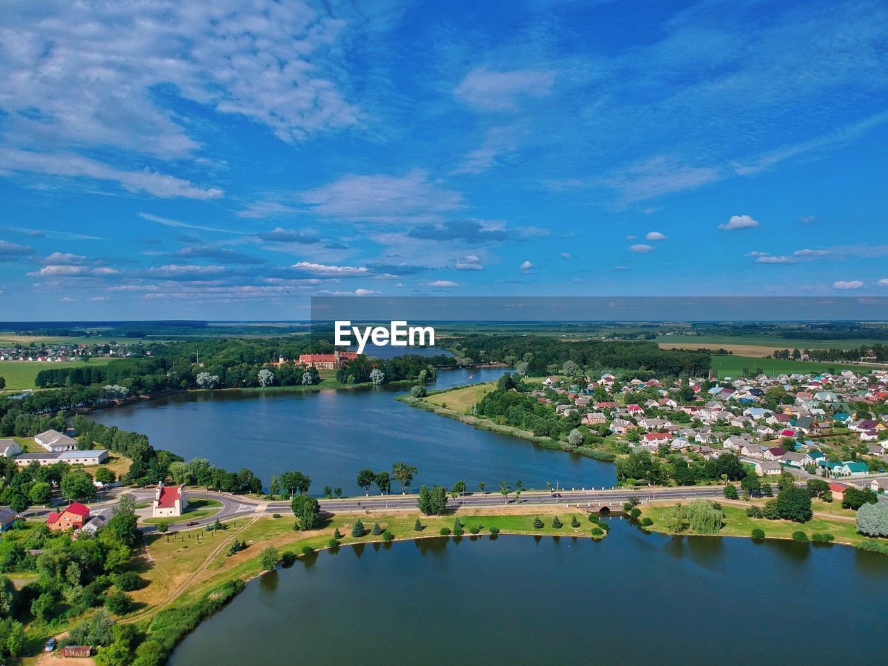 HIGH ANGLE VIEW OF RIVER AMIDST CITYSCAPE AGAINST BLUE SKY