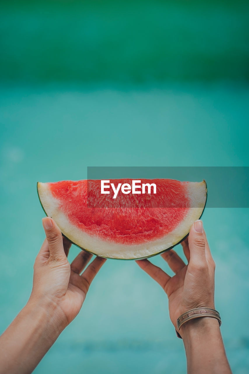 Watermelon held up outside during a hot and sunny day.