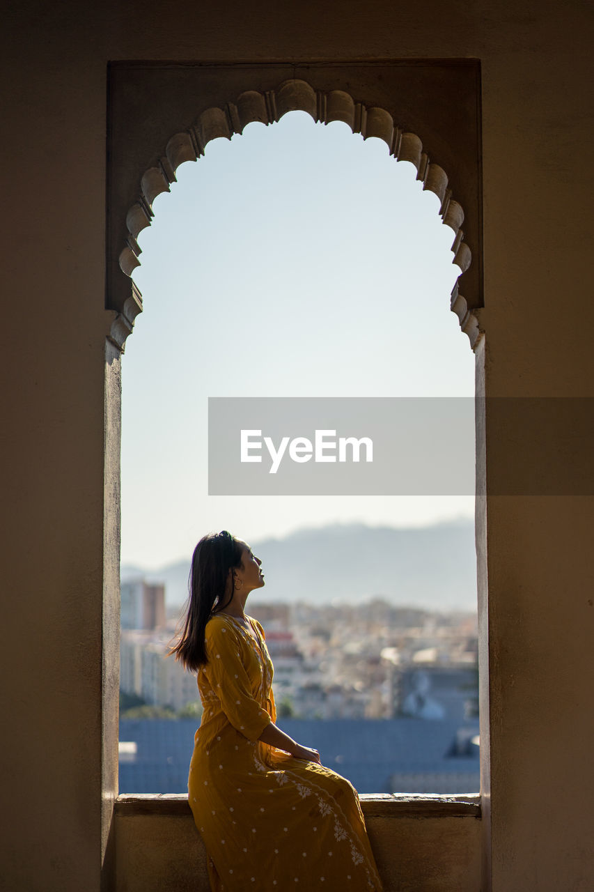 Female traveler in arch of old fortress