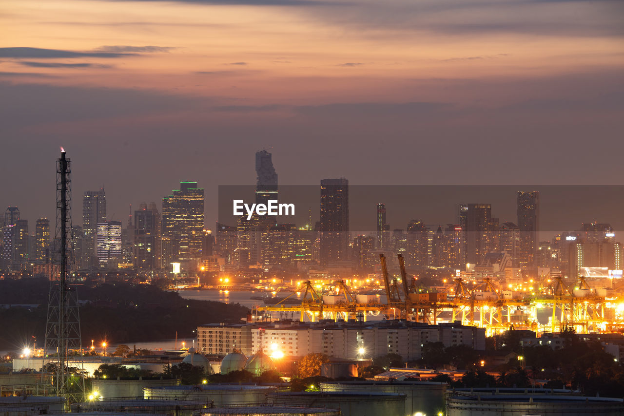 ILLUMINATED BUILDINGS IN CITY AGAINST SKY AT SUNSET