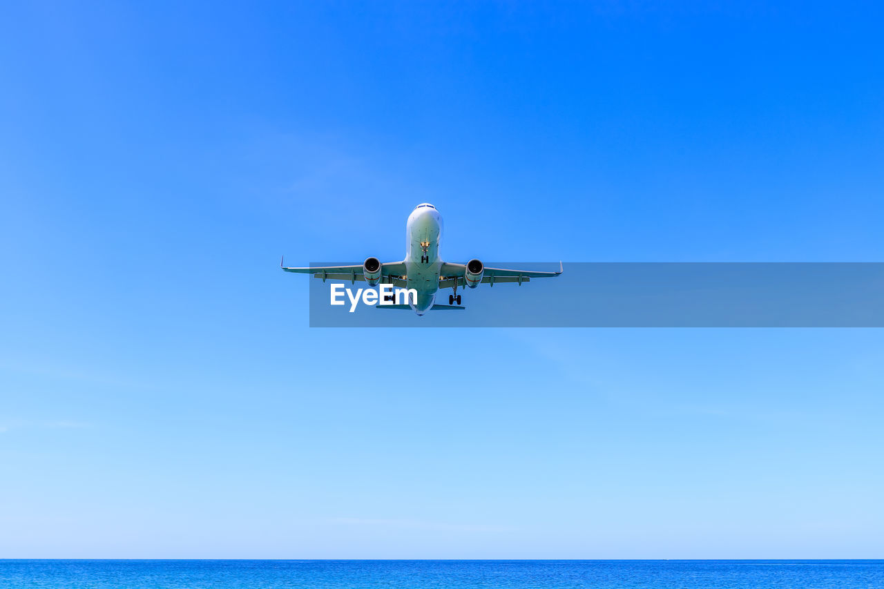LOW ANGLE VIEW OF AIRPLANE IN SEA AGAINST SKY