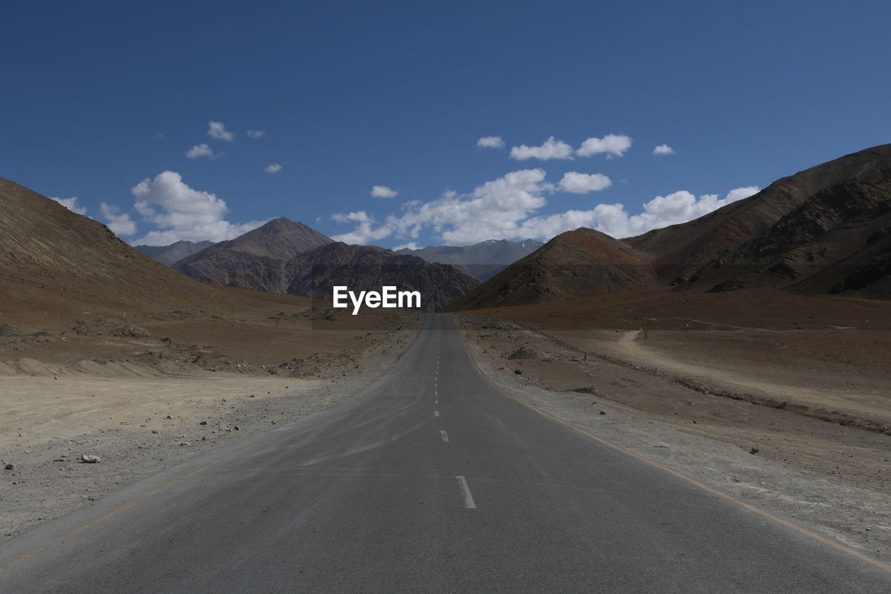 Empty road along countryside landscape