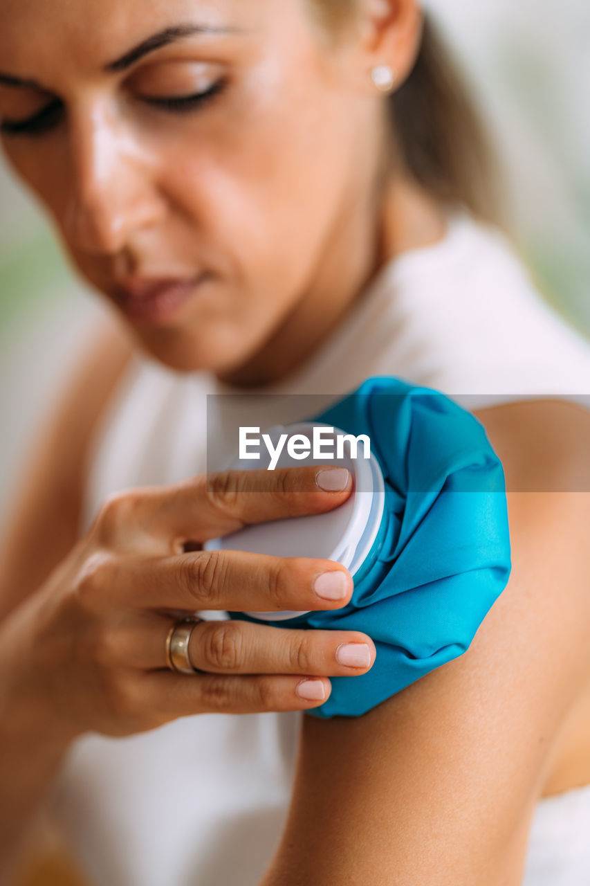 Frozen shoulder. woman holding cold compress, ice bag pack on her painful shoulder