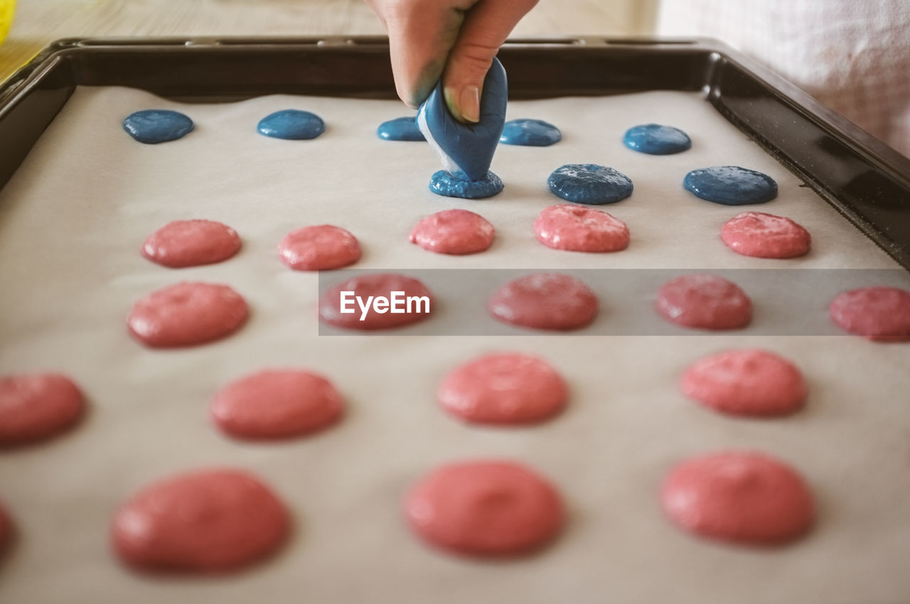 Cropped image of hand making cookies in baking sheet