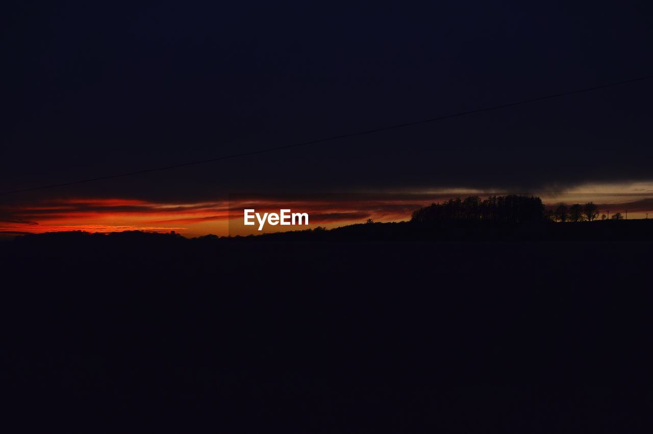 Silhouette landscape against sky at night