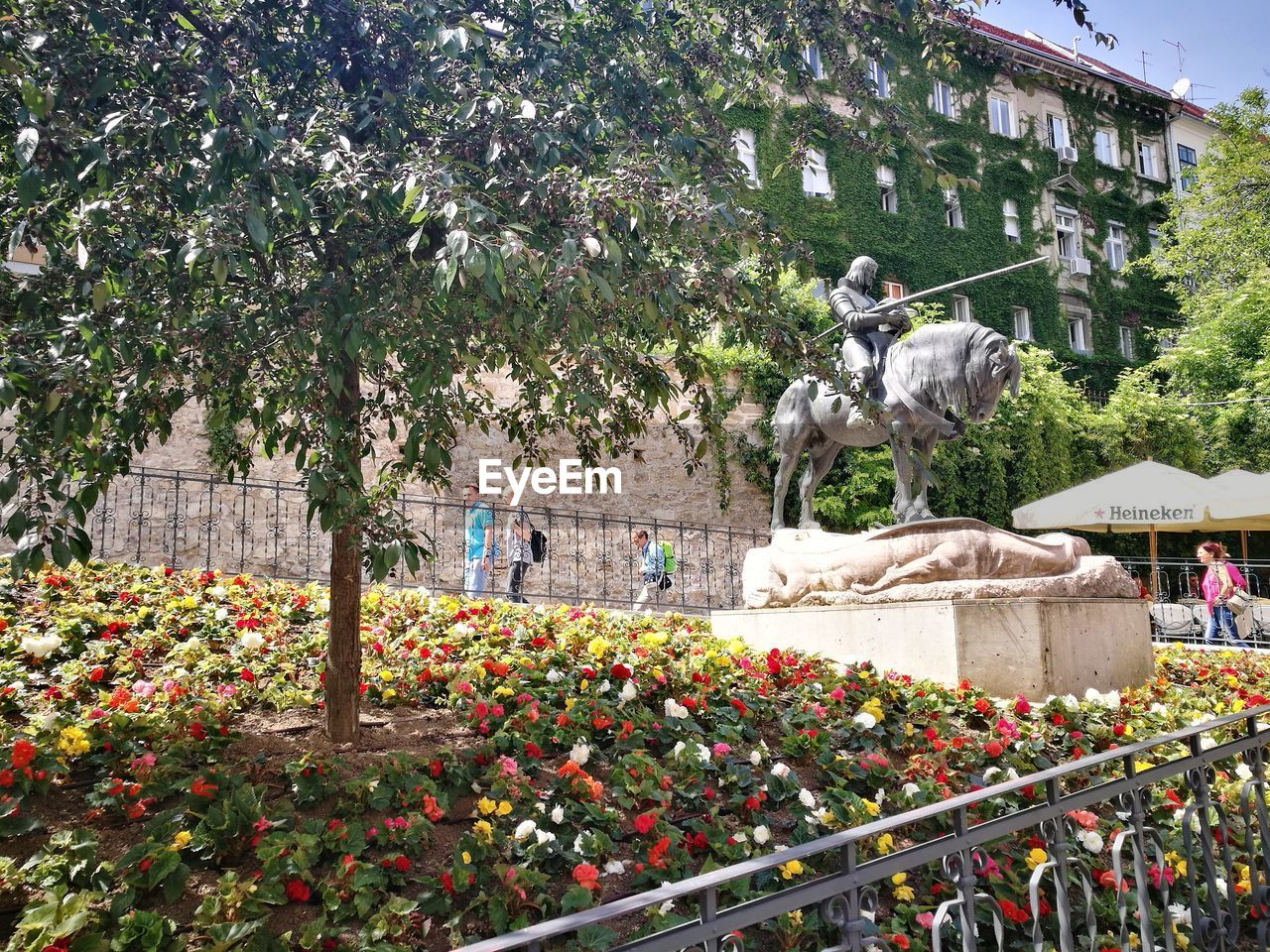 STATUE AGAINST TREES AND BUILDINGS