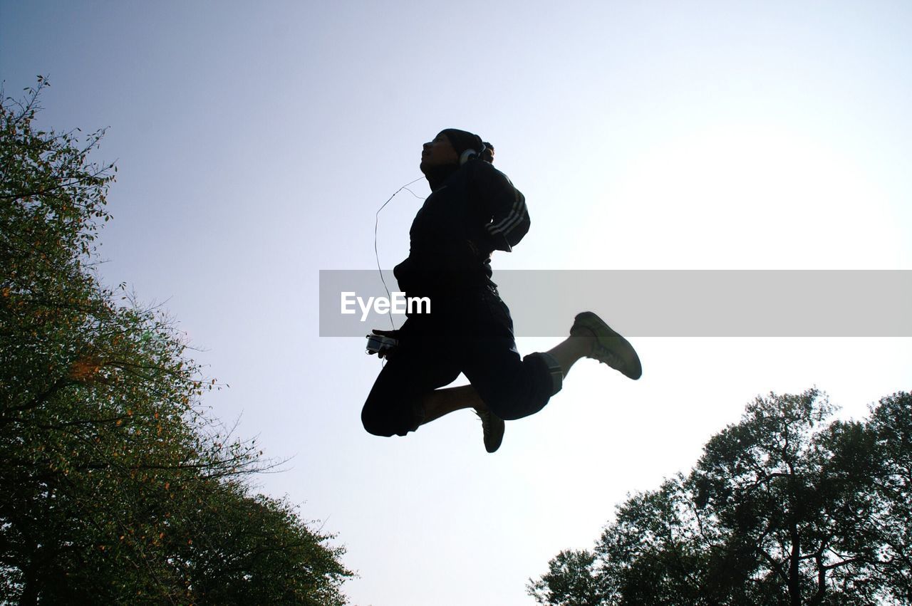 LOW ANGLE VIEW OF PEOPLE JUMPING IN SKY