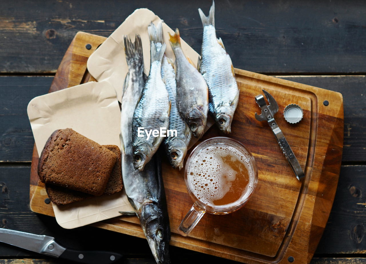 Glasses of beer, slices of black bread and dried fish on a kitchen cutting board. food background.