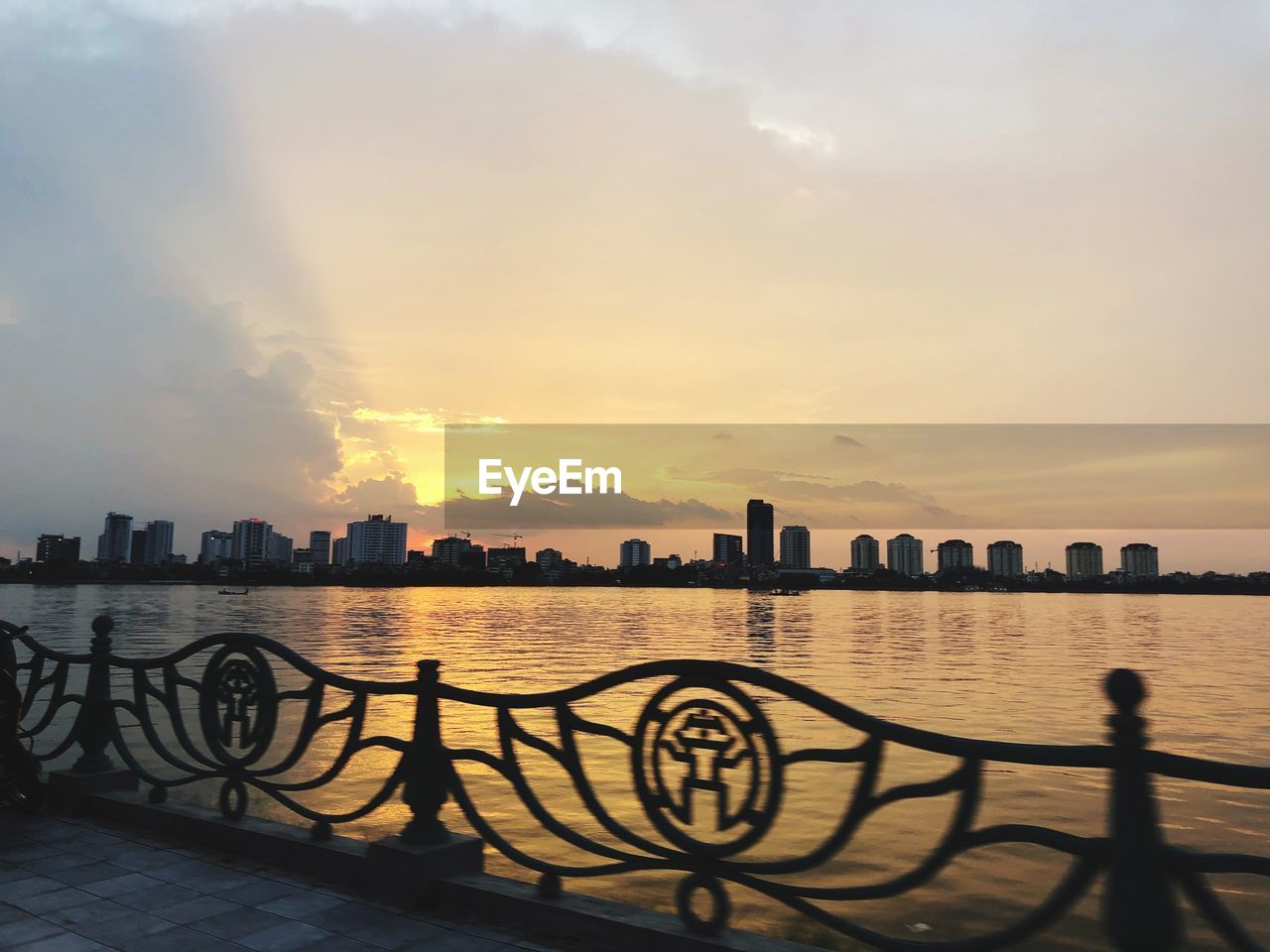 SILHOUETTE BUILDINGS AGAINST SEA DURING SUNSET