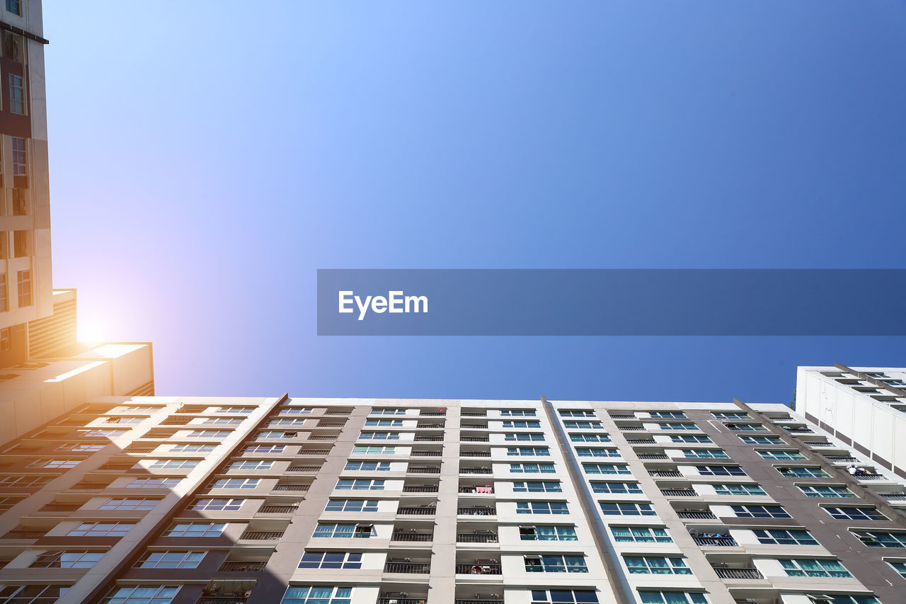 Low angle view of buildings against clear blue sky