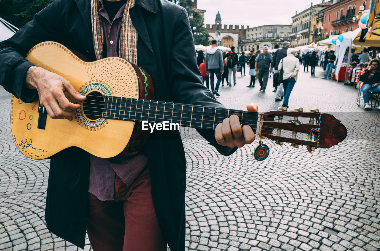 Man playing guitar on city street