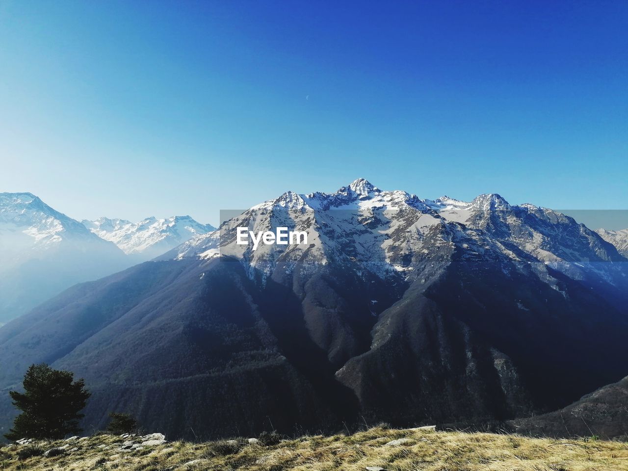 Scenic view of snowcapped mountains against clear blue sky