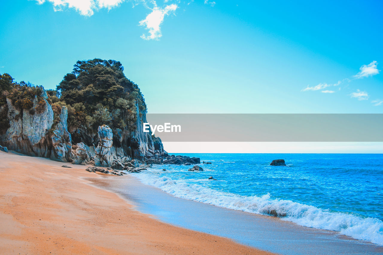 Scenic view of beach against blue sky