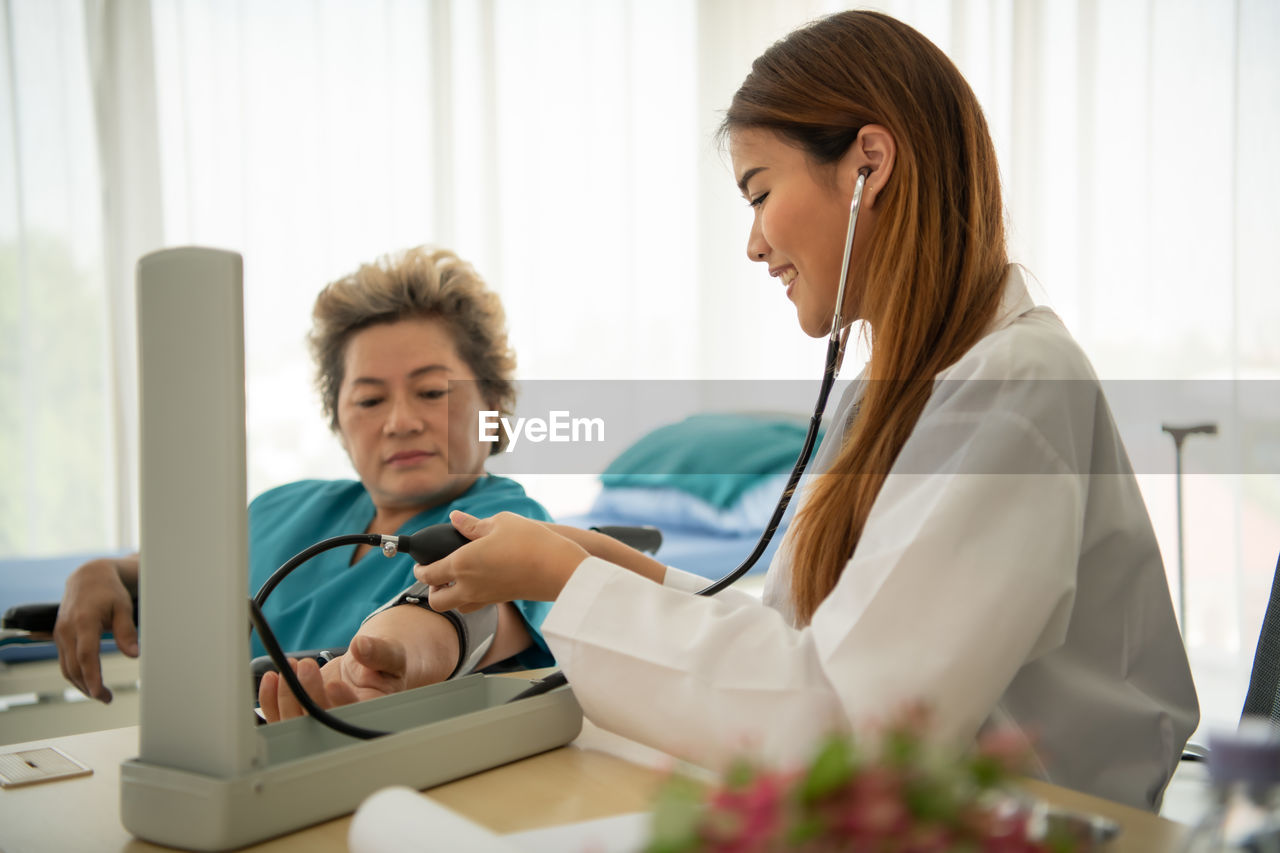 Young woman using phone while sitting on table