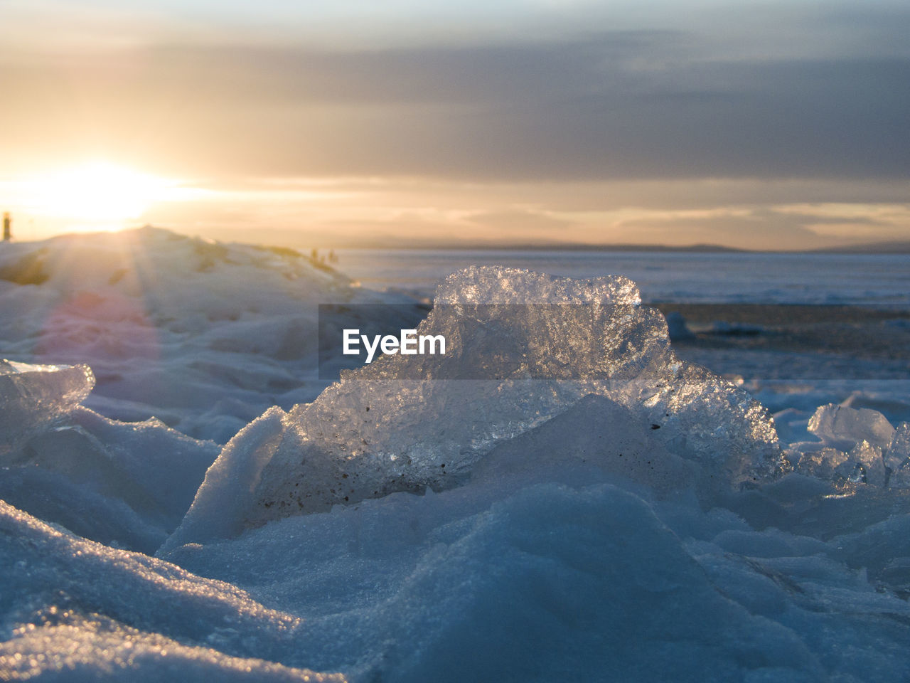 Close-up of ice at frozen lake neusiedl against sky during sunset