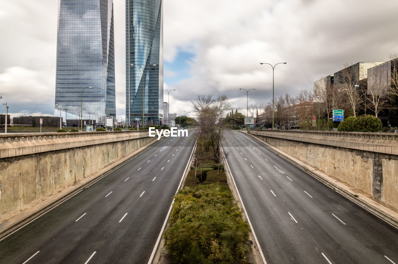 High angle view of highway against cloudy sky in city