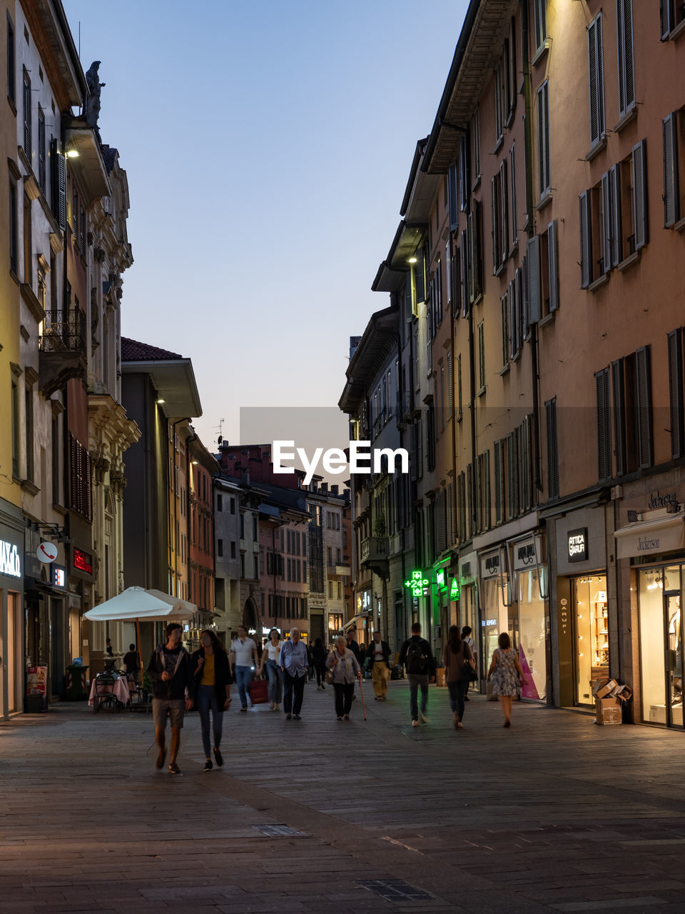 PEOPLE WALKING ON STREET AGAINST BUILDINGS IN CITY