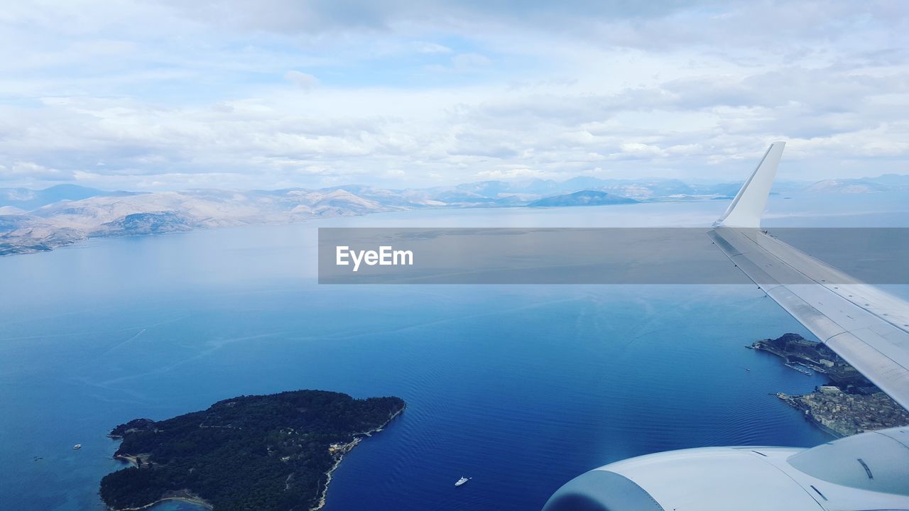 Airplane flying over sea against sky