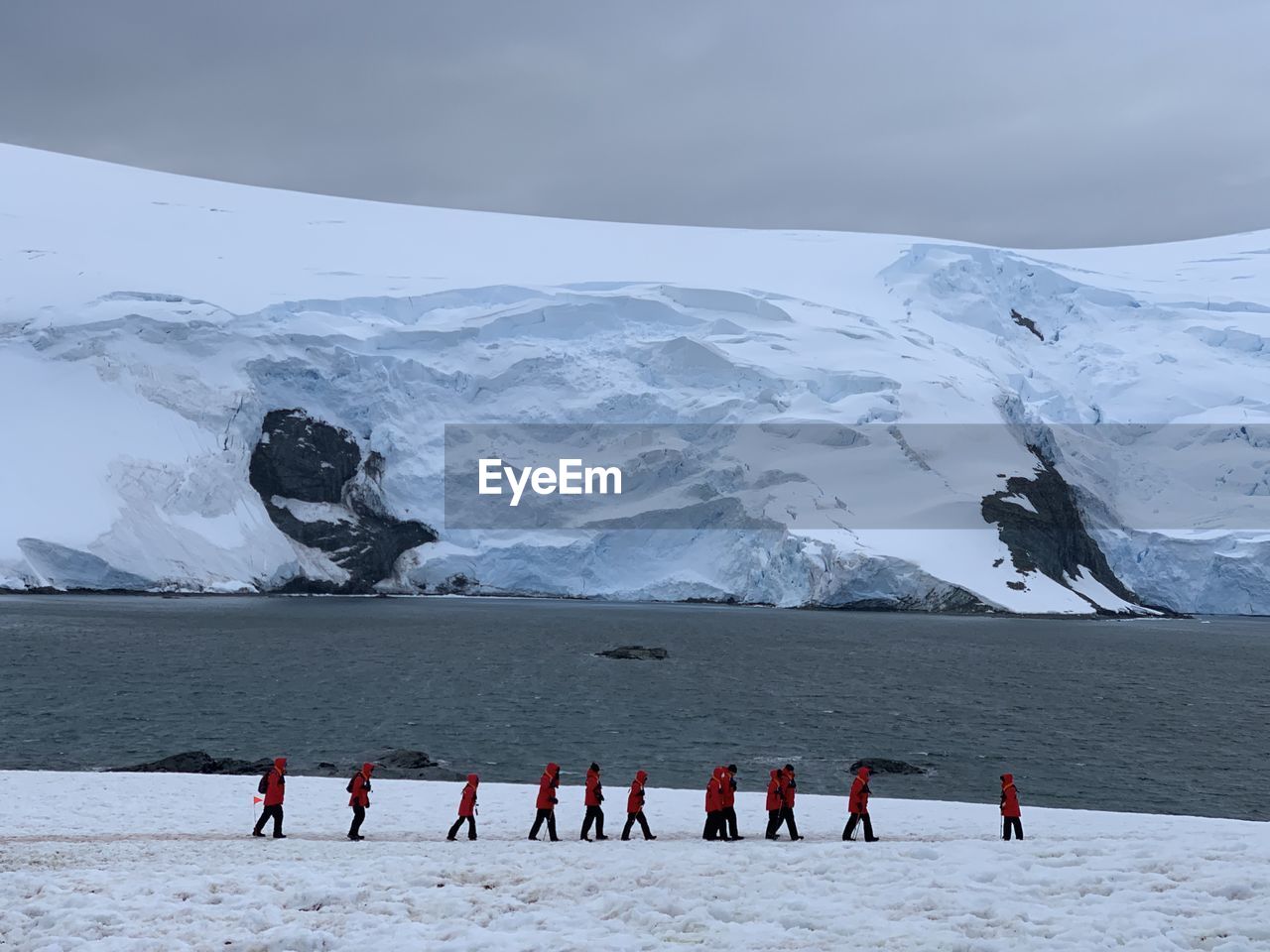 Rear view of people on snowcapped mountain