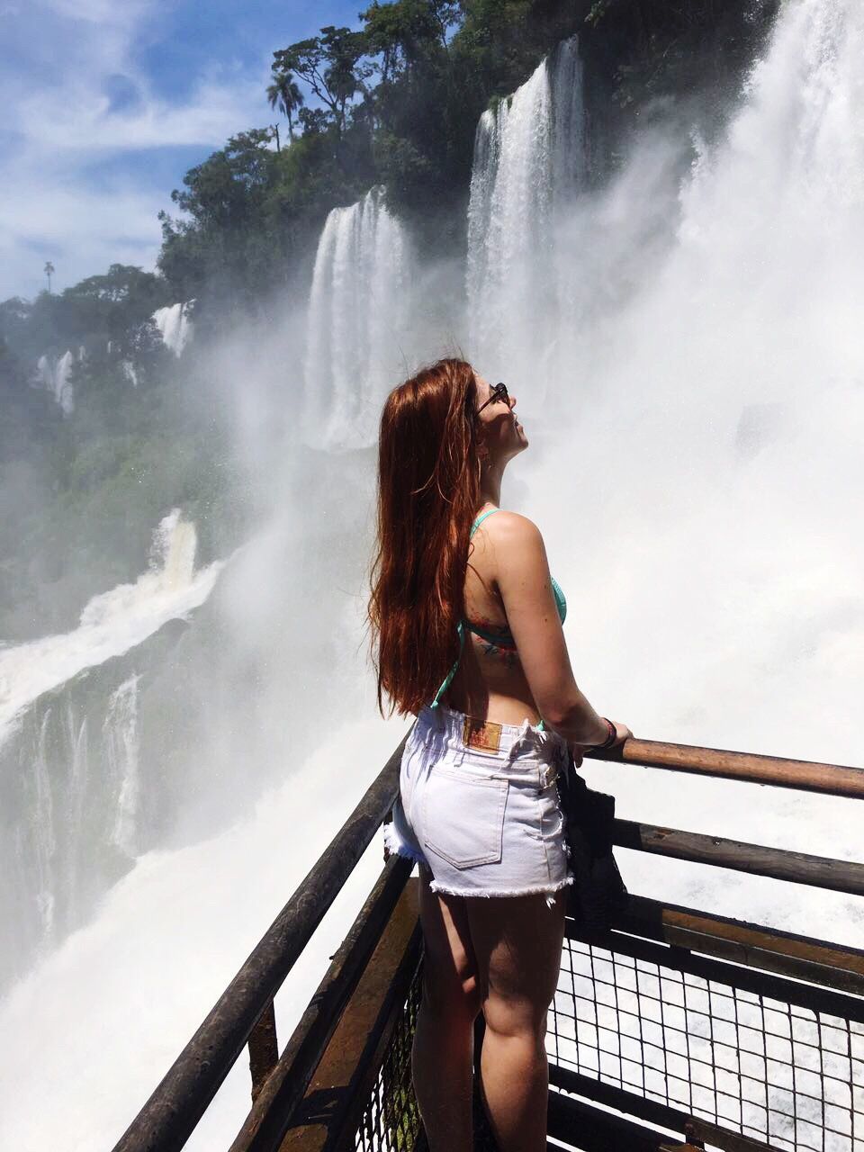 BEAUTIFUL YOUNG WOMAN AGAINST WATERFALL