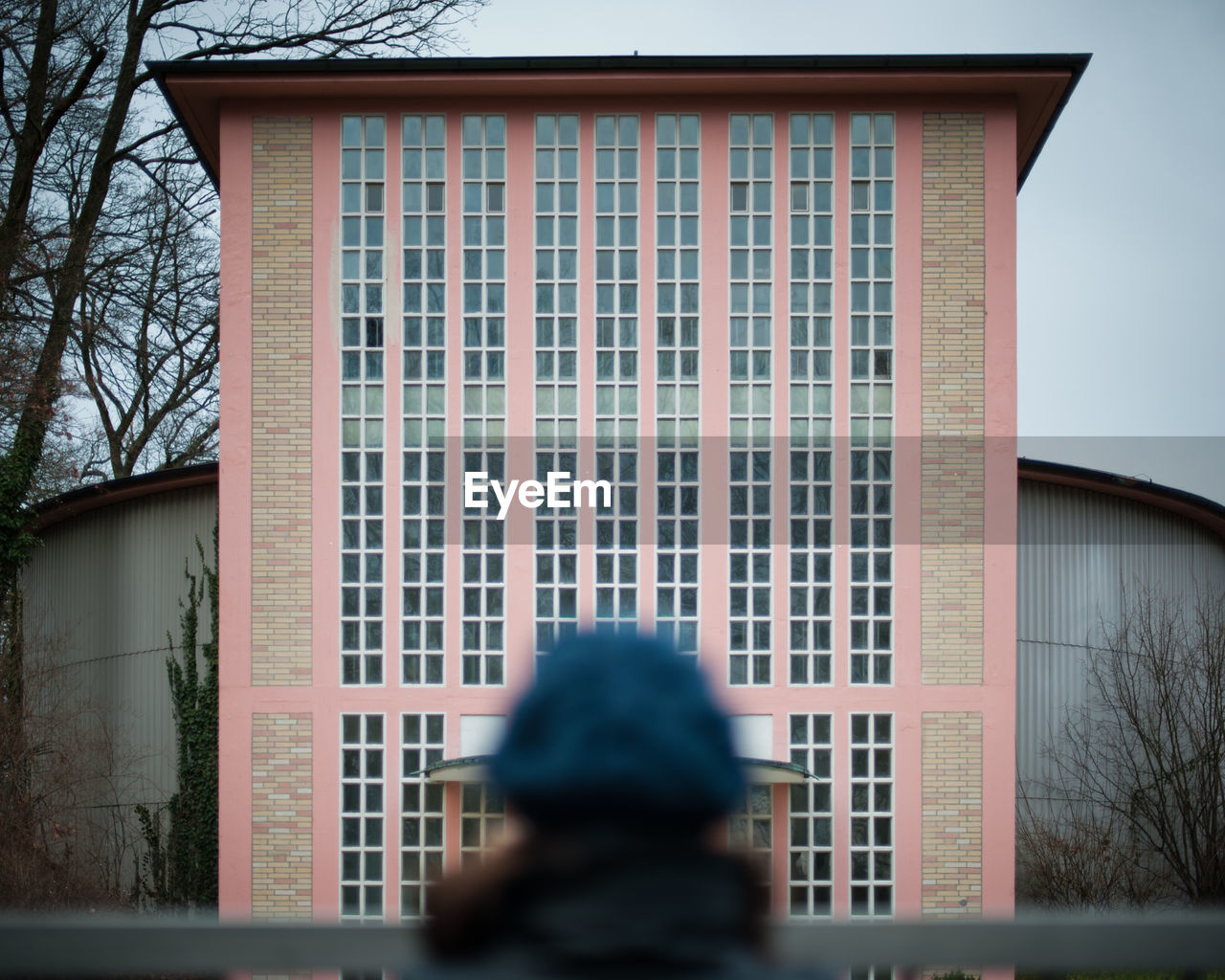 PORTRAIT OF PERSON BY WINDOW AGAINST BUILDING