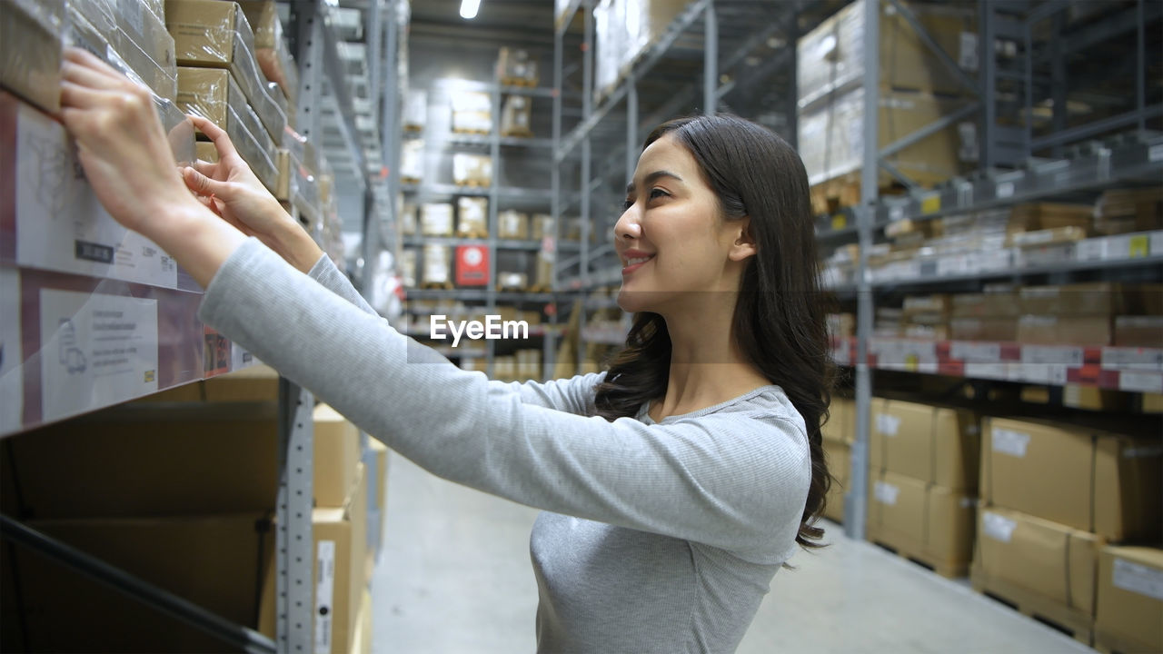 Side view of young woman looking away at store