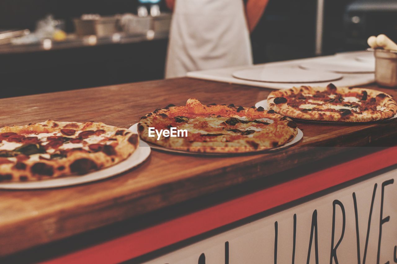 Man preparing pizza on table in restaurant