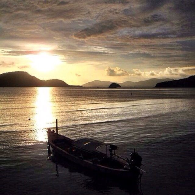 BOATS IN SEA AT SUNSET