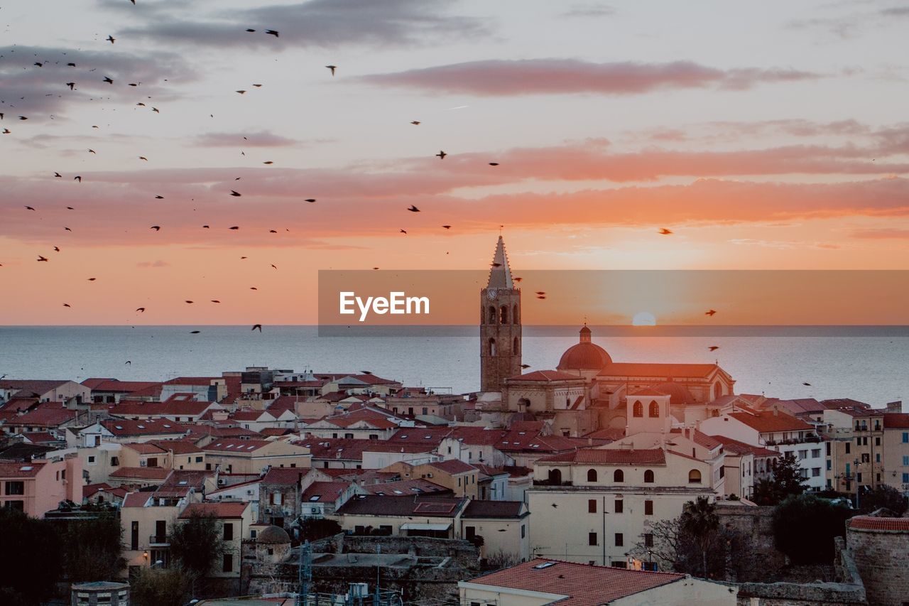 TOWN BY SEA AGAINST SKY DURING SUNSET