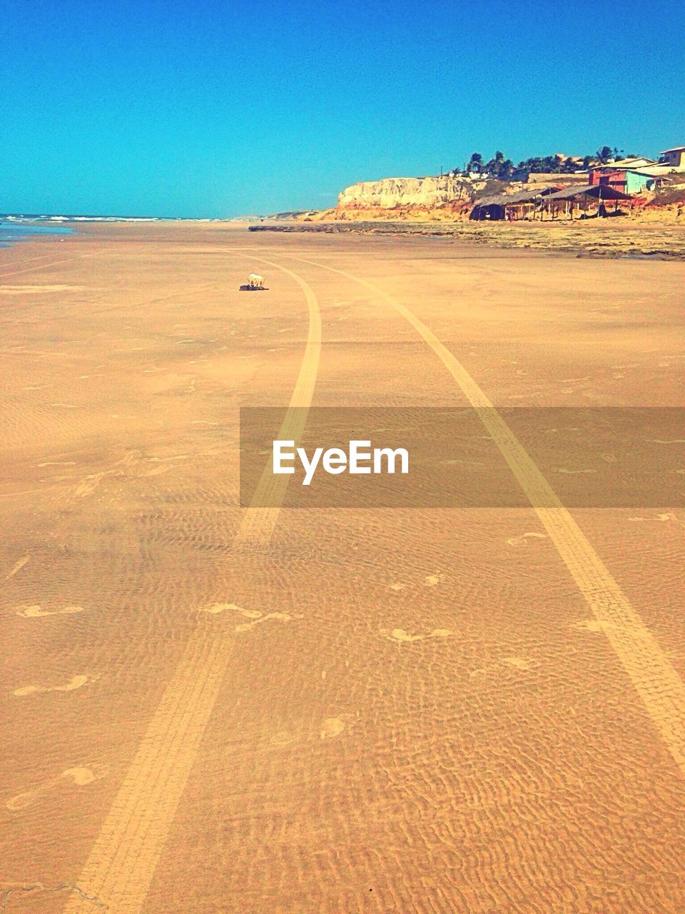 Scenic view of beach against clear blue sky