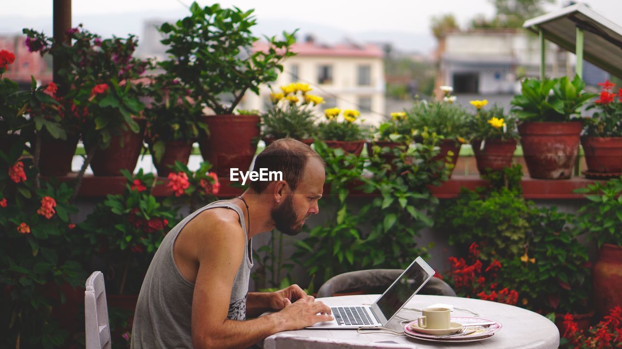 Man using laptop while sitting at table