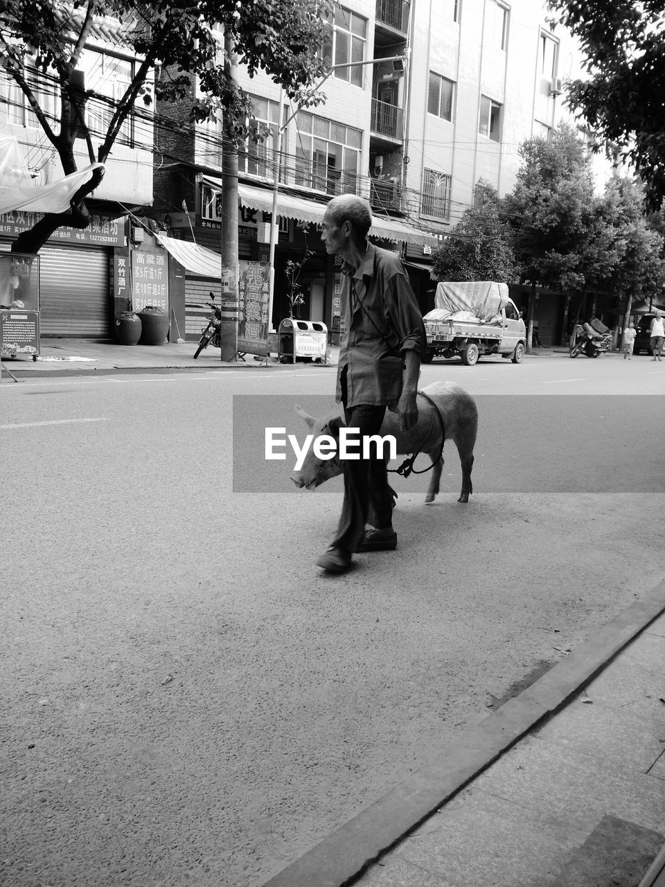 REAR VIEW OF WOMAN WALKING ON STREET