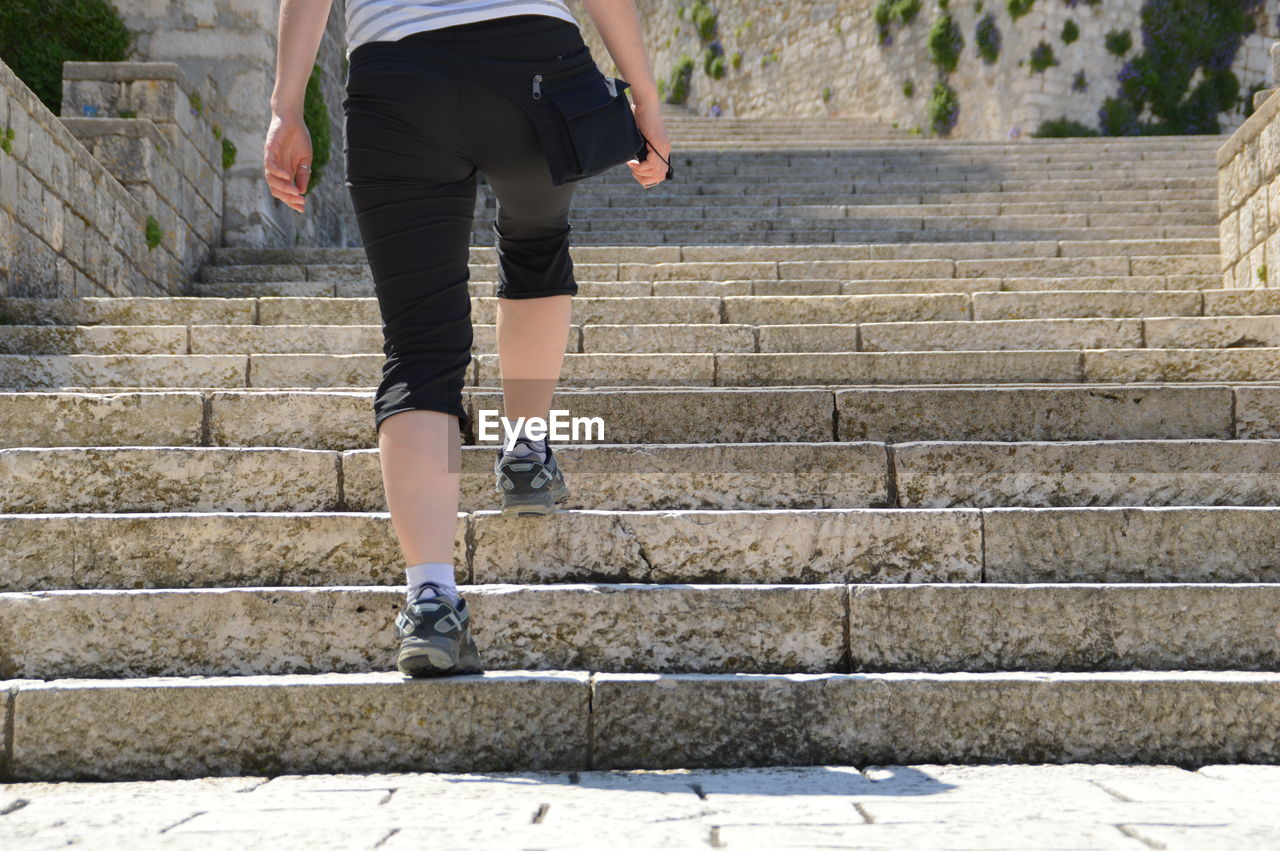 Low section of woman moving on steps