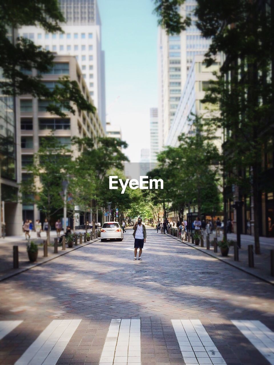 Tilt shift image of man walking on street