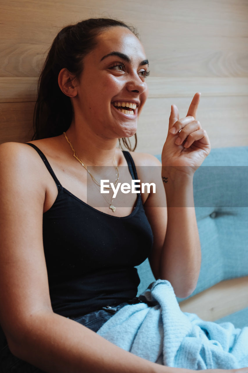 Smiling young woman sitting at home