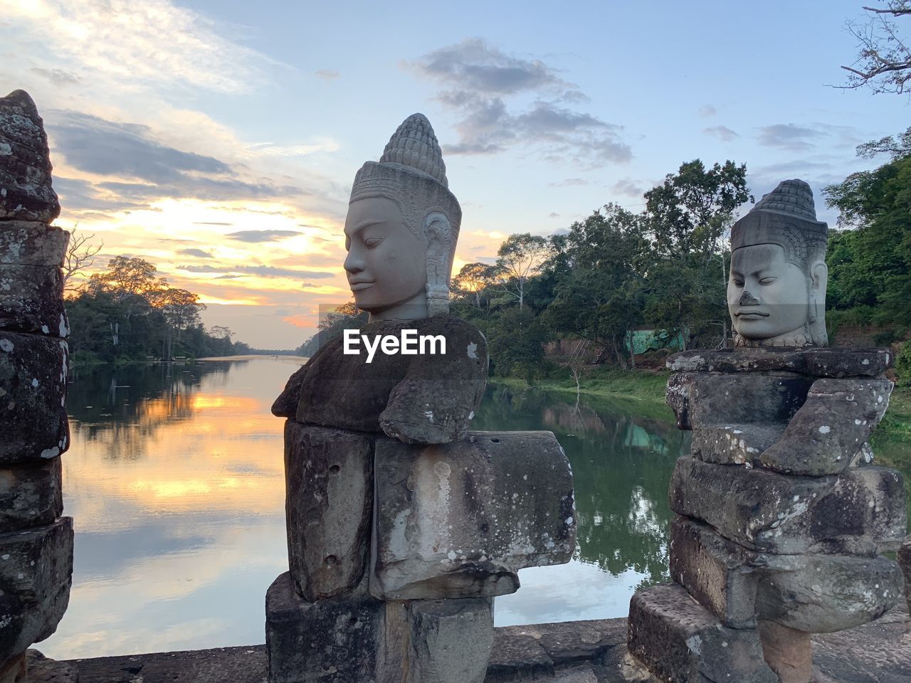 STATUE OF BUDDHA AGAINST SKY AT TEMPLE