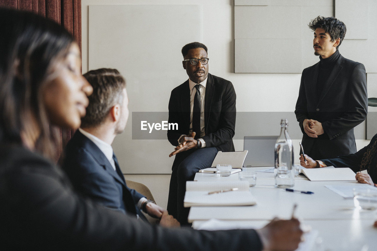 Male entrepreneur planning business strategy with colleagues during meeting at office