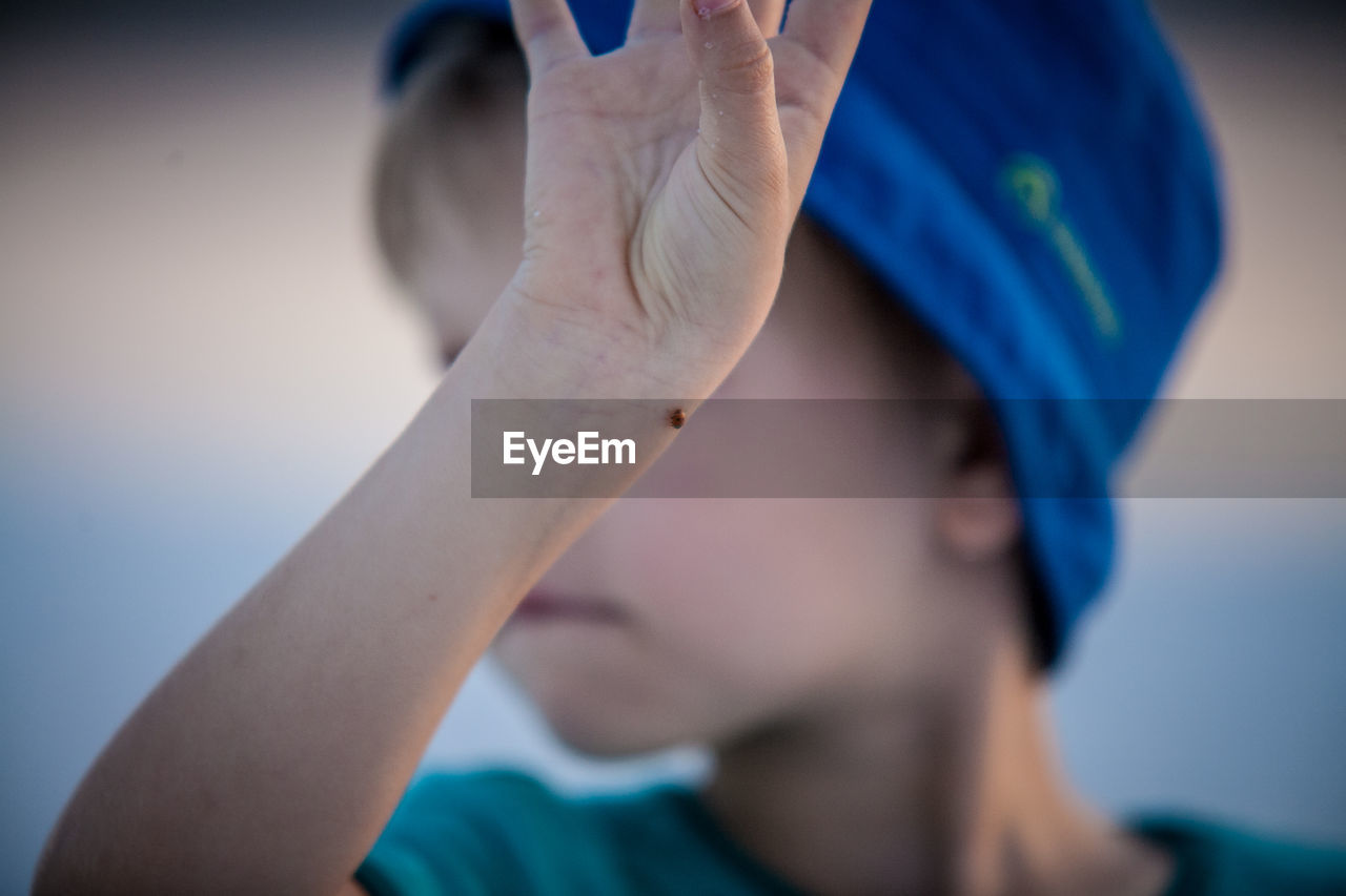 Close-up of bug on boy hand