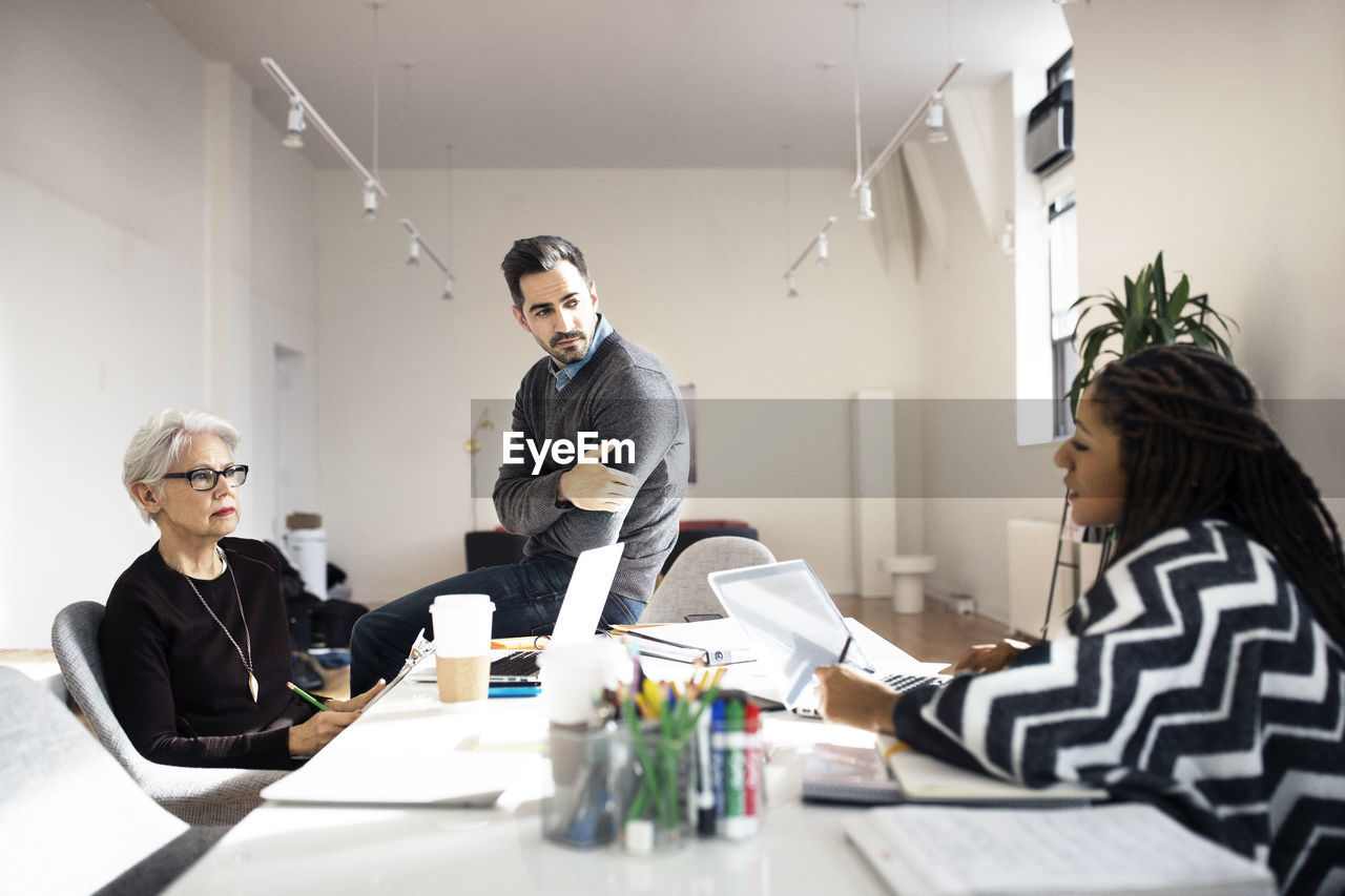 Business people discussing on table in creative office