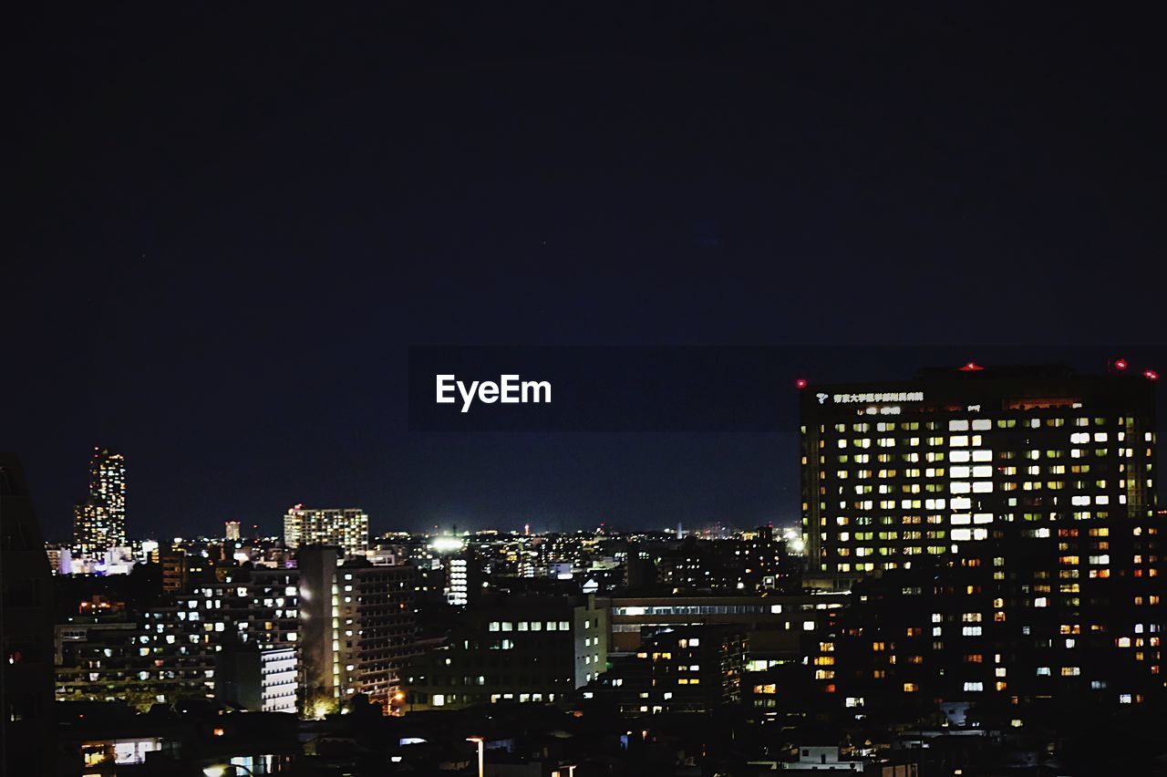 Illuminated cityscape against sky at night