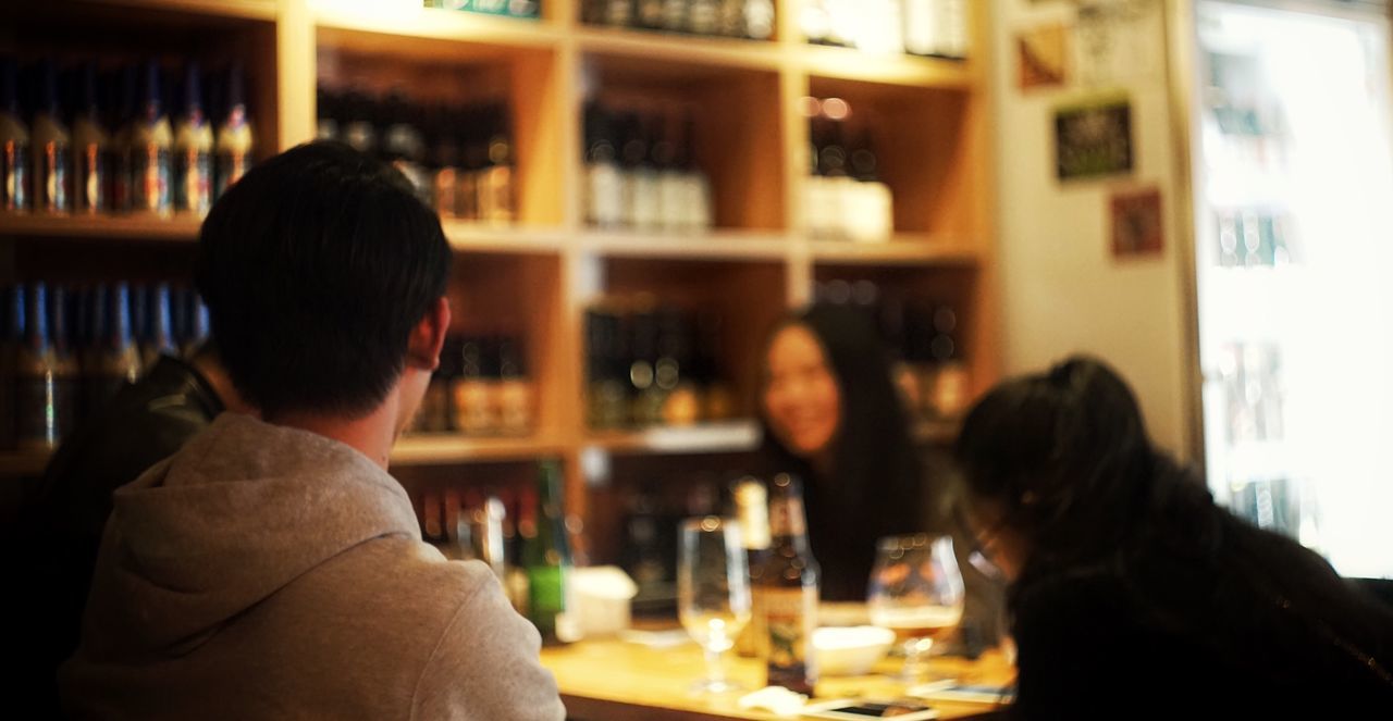 Rear view of man with friends sitting in bar