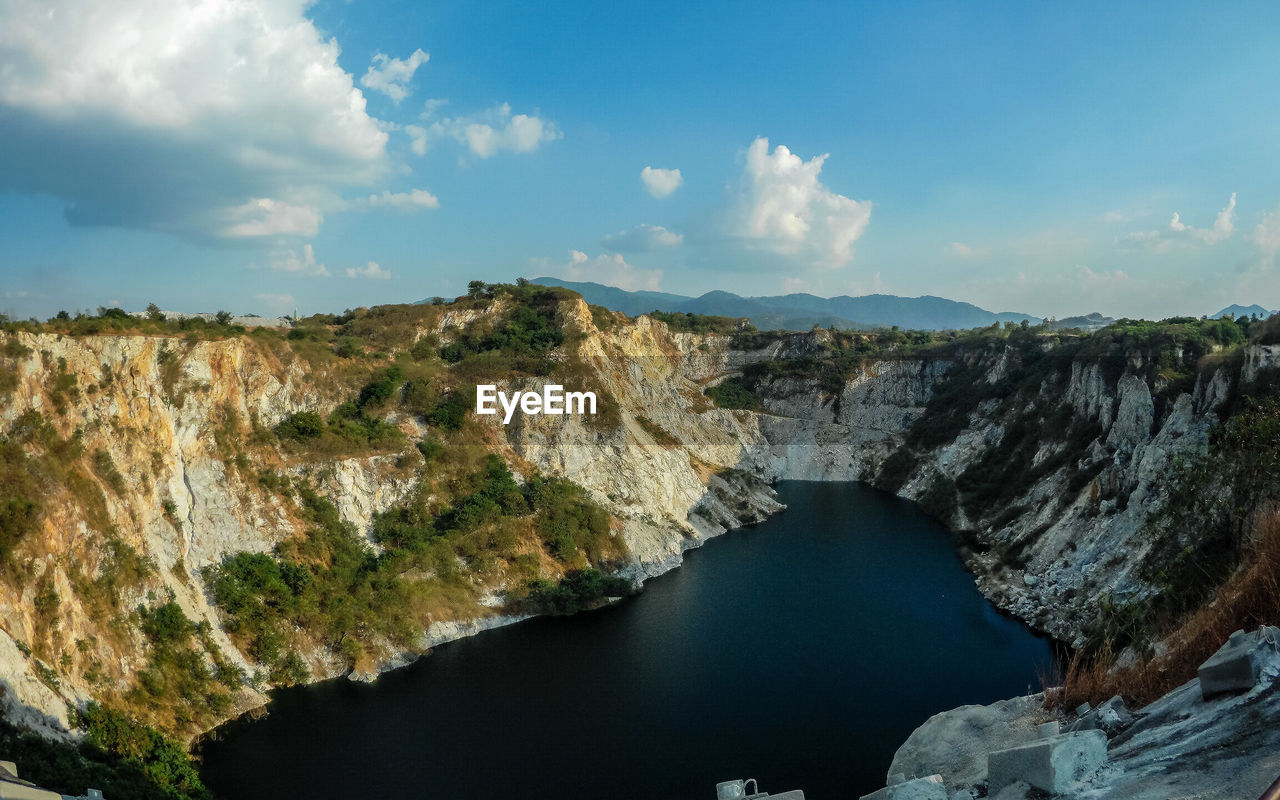 PANORAMIC SHOT OF ROCKS ON SHORE AGAINST SKY